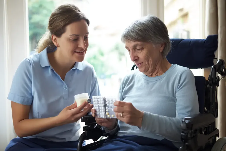 Registered nurse assisting NDIS participant with medication at home in Melbourne